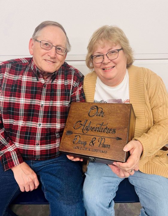 Pam and Doug Knowles holding the carved wooden box 